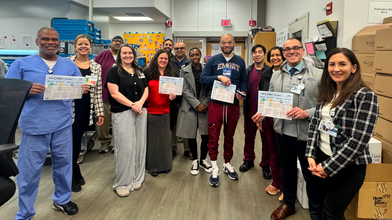 Emory Healthcare pharmacy team members holding GROSS By The Numbers reports